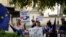Brexit opponents wave flags and hold signs near the Houses of Parliament in central London, England, Aug. 28, 2019.