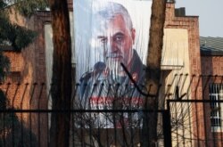 FILE - A picture of Iranian Major General Qassem Soleimani, head of the elite Quds Force, who was killed in an airstrike at Baghdad airport, is seen on the former U.S. Embassy's building in Tehran, Iran, Jan. 7, 2020.