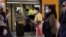 FILE - Sydney commuters wear protective face masks on public transit amid new public health regulations from the state of New South Wales, as the city grapples with an outbreak of COVID-19 June 23, 2021.