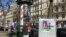 A man walks past campaign posters in Paris, March 15, 2020. (L. Bryant/VOA)