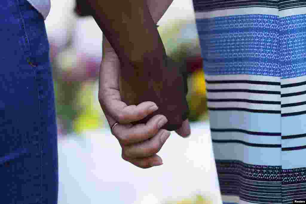 Mourners hold hands outside the Emanuel African Methodist Episcopal Church in Charleston, South Carolina, June 18, 2015.