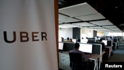 FILE - Employees work inside Uber's Center of Excellence office in Cairo, Egypt, Oct. 10, 2017. 