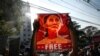 Seorang pengunjuk rasa memegang poster Aung San Suu Kyi selama demonstrasi menentang kudeta militer di depan Bank Sentral Myanmar di Yangon, 15 Februari 2021. (Foto: AFP)