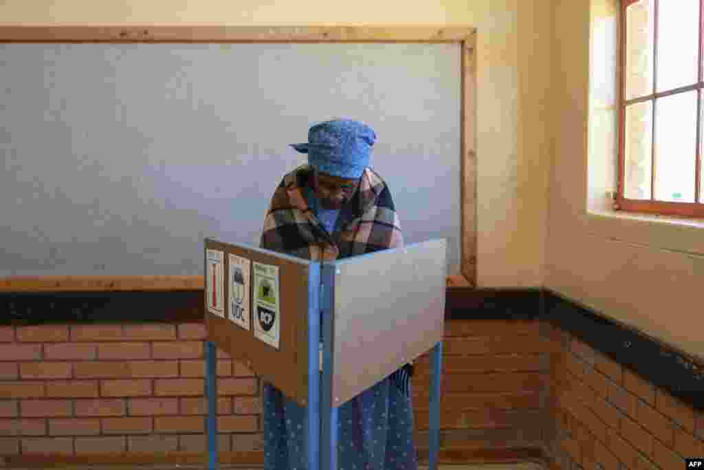 An elderly voter marks her ballot in a voting booth at Mosielele Primary School polling station in Moshupa Village, west of Gaborone, during Botswana&#39;s general election.