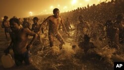 ຊາວຮິນດູຄົນນຶ່ງ ເຕັ້ນຂື້ນເຕັ້ນລົງ ໃນຂະນະທີ່ລາວອາບນໍ້າຢູ່ ແມ່ນໍ້າຄົງຄາ ທີ່ ອິນເດຍ ໃນໂອກາດບຸນ Kumbh Mela.