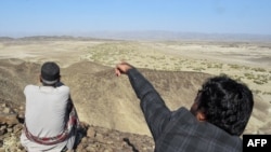 一名居民2024年1月18日展示巴基斯坦西南部俾路支省邊境地區的一座山，此前伊朗對那裡發動空襲。（法新社照片）