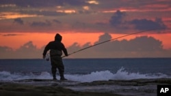 Tareq Aweid fishes at sunset near the border with Lebanon in Nahariya, Israel, Nov. 28, 2024. Aweid said he did not think the 60-day ceasefire between Hezbollah and Israel would last long. "No, no, the rockets will fall again."