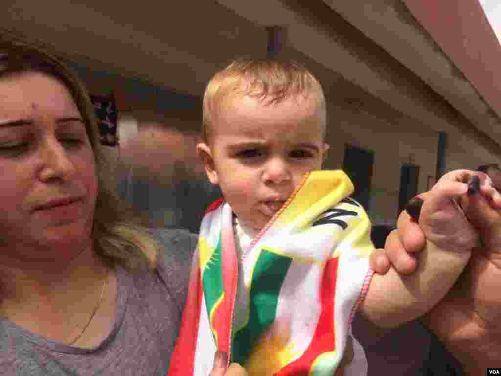 A Kurdish woman holds up her six-month-old boy, Botan, with ink on his hand, which symbolizes to their family that the future of Kurdistan is independence, in Irbil, Iraqi Kurdistan, Sept. 25, 2017. (H. Murdock/VOA)