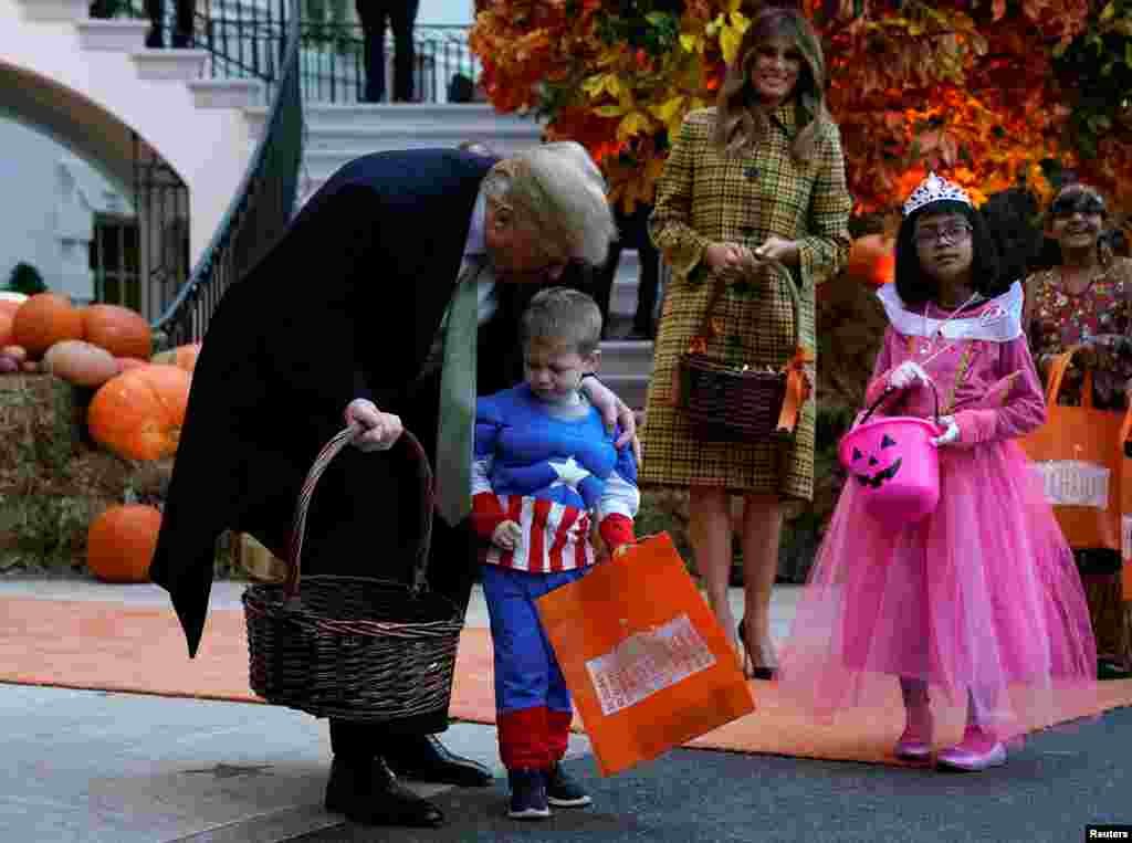 El mandatario y su esposa repartieron chocolatinas Twizzlers y Hershey con el sello de la Casa Blanca a las decenas de niños de familias militares que participaron en la festividad de Halloween.