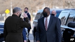 Defense Secretary Lloyd Austin, right, is saluted by Chairman of the Joint Chiefs of Staff Mark Milley as he arrives at the Pentagon, Jan. 22, 2021, in Washington.