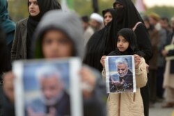 Protesters carry posters with the image of top Iranian commander Qassem Soleimani, who was killed in a U.S. airstrike in Iraq, during a demonstration in Islamabad.