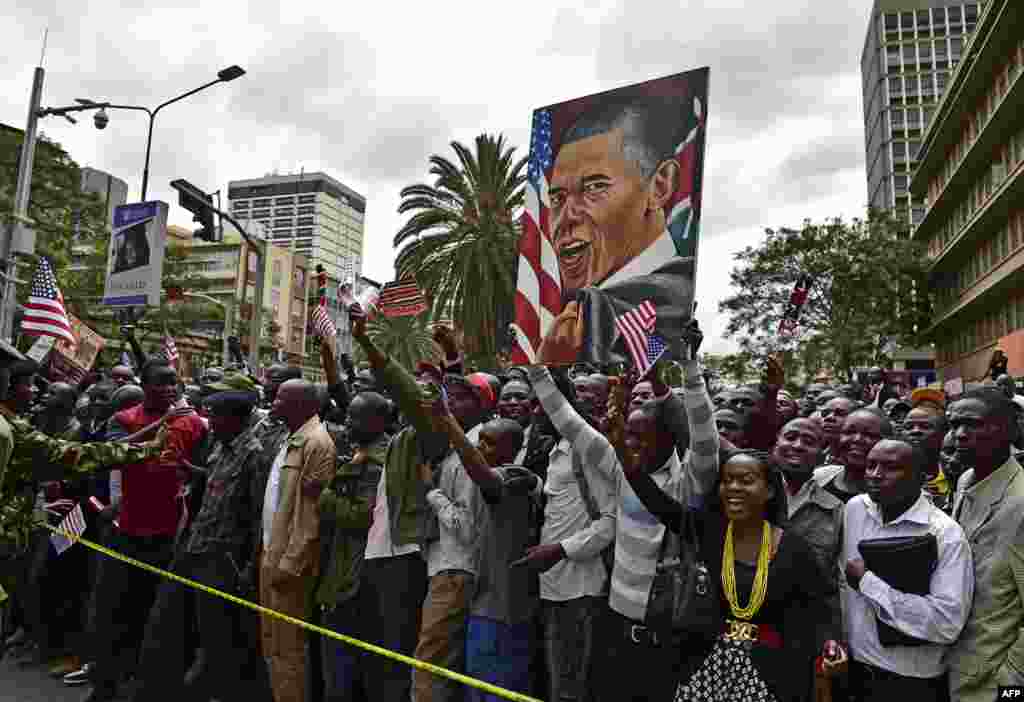 Crowds of Kenyans cheer and hold a painting representing US President Barack Obama near Memorial Park, in Nairobi on July 25, 2015. 