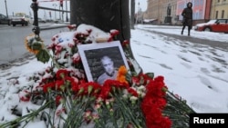 A portrait of Russian military blogger Vladlen Tatarsky, (real name Maxim Fomin), who was killed in the cafe explosion the day before, is placed among flowers near the blast site in Saint Petersburg, Russia April 3, 2023. 