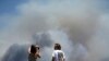 Chase and Brittany Boslet take pictures of smoke from the Las Pulgas fire burning on the Marine Corps Base Camp Pendleton near Oceanside, California, May 16, 2014.