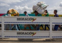 Men carry large loads on their backs as they work as “lomo taxistas,” or taxis of the lower back, across the border from Cucuta, Colombia, to Venezuela, Sept. 20, 2019.