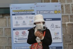 Женщина в медицинской маске на улице в Сеуле, Южная Корея