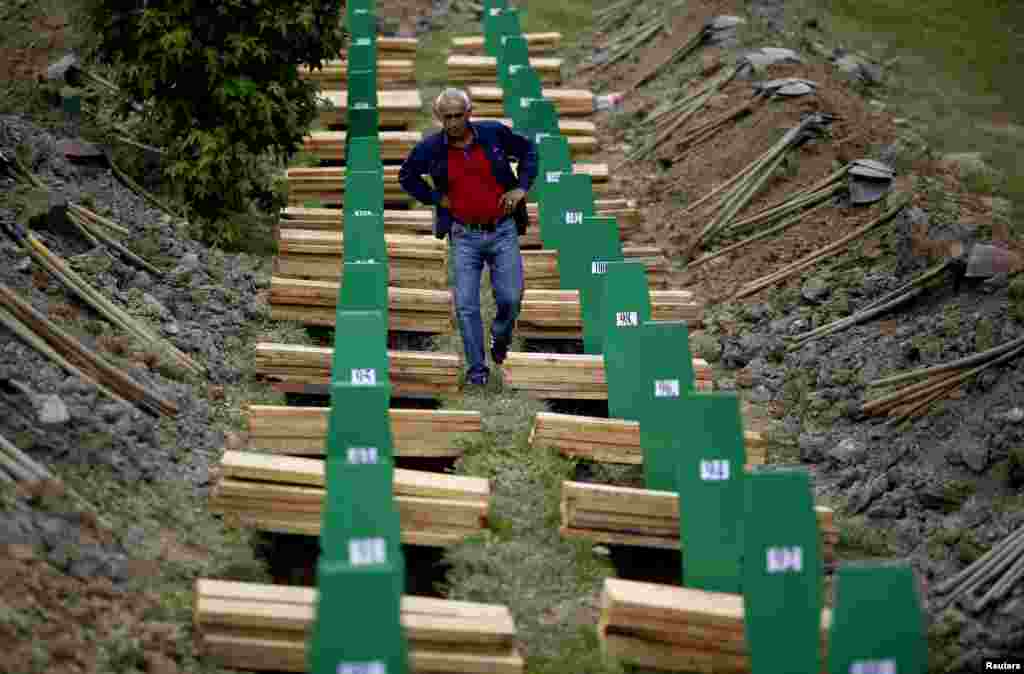 Seorang pria Muslim Bosnia&nbsp;mencari peti jenazah saudaranya yang tewas dalam pembantaian Srebrenica tahun 1995.