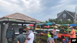 Tourists to North Carolina's Ocracoke Island visit Ride the Wind Surf Shop, June 25, 2020.