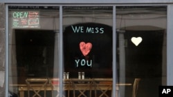 A message is posted on the front window of the Ranging Bull Saloon, which remains closed during the coronavirus pandemic, in Augusta, Maine, April 28, 2020. 