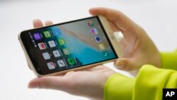 A woman shows the new LG's G5 smartphone during the LG unpacked 2016 event on the eve of this week’s Mobile World Congress wireless show, in Barcelona, Spain, Feb. 21. 2016. 