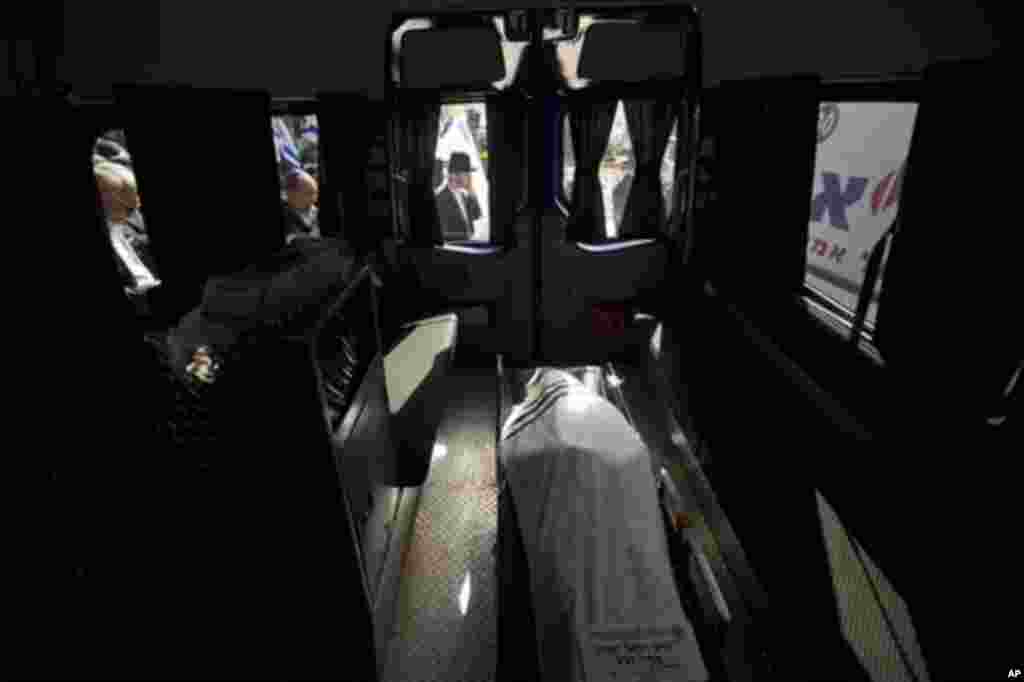 The body of Rabbi Jonathan Sandler lies in a hearse at the cemetery during his funeral in Jerusalem, Wednesday, March 21, 2012. Sandler and three children gunned down at a Jewish school in France were buried Wednesday in a Jerusalem cemetery. The four wer