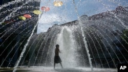 A boy plays in a fountain in Berlin, Germany, July 24, 2019.