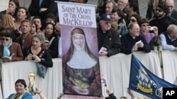 Faithful hold a banner of Saint Mary of the Cross MacKillop, of Australia, during a Canonization Mass celebrated by Pope Benedict XVI in St. Peter's square at the Vatican, Sunday, Oct. 17, 2010