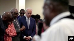 FILE - President Joe Biden, fourth left, bows his head as Reverend Dr. Jamey O. Graham Sr., in foreground at right, speaks at St. John Baptist Church, in Columbia, S.C., on January 28, 2024.