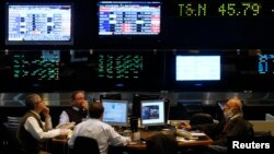 FILE - Argentine stockbrokers work on the floor of the Buenos Aires Stock Exchange June 16, 2014.