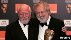 Director David Putnam (R) is embraced by fellow British Director Richard Attenborough (L) after winning the Fellowship Award at the British Academy of Film and Television Arts awards in central London in this February 19, 2006 file photo.