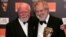 Director David Putnam (R) is embraced by fellow British Director Richard Attenborough (L) after winning the Fellowship Award at the British Academy of Film and Television Arts awards in central London in this February 19, 2006 file photo