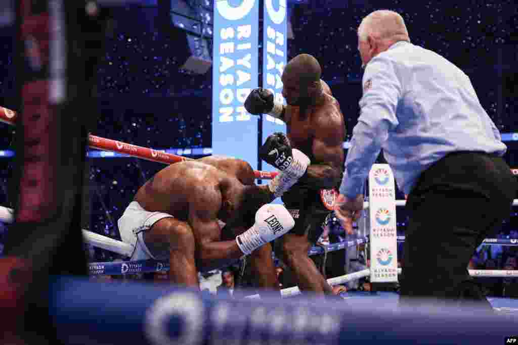 Moyi Grande-Bretagne Anthony Joshua (G) agumbami na makofi ya moyi Grande-Bretagne mosusu Daniel Dubois na bitumba ya ba poids lourds ya nkamba ya molongo ya IBF na etando ya masano ya Wembley, Londres, Sanza 21 2024. (Photo by Adrian Dennis / AFP) 