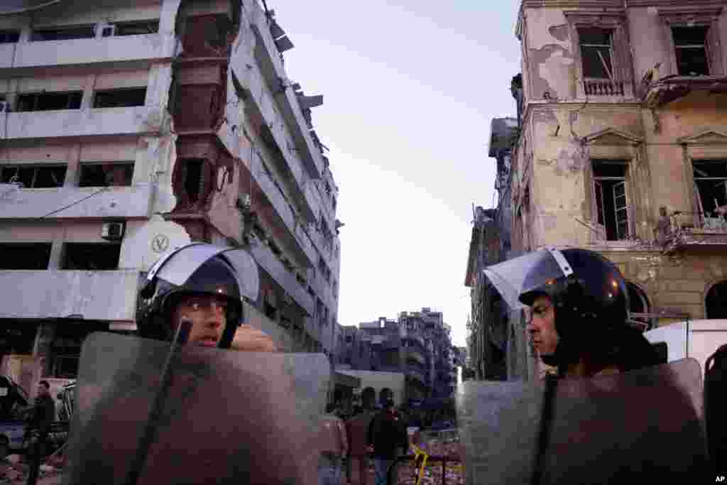 Egyptian police stand guard at the scene of a powerful explosion at a police headquarters building in the Nile Delta city of Mansoura, Egypt, Dec. 24, 2013.