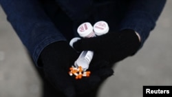 FILE - A fentanyl user displays opioid alternatives, including morphine pills, in Vancouver, British Columbia, Canada, April 6, 2020. 