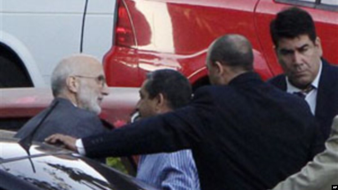 Surrounded by security forces, US government contractor Alan Gross, left, arrives to a courthouse to attend a trial in Havana, Cuba, March 5, 2011