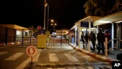 FILE - People wait to cross to Egypt at the Israeli side of the Taba crossing near the Red Sea resort of Eilat, Feb. 16, 2014. Israel closed its part of the crossing Monday following warnings of an “imminent” militant attack.