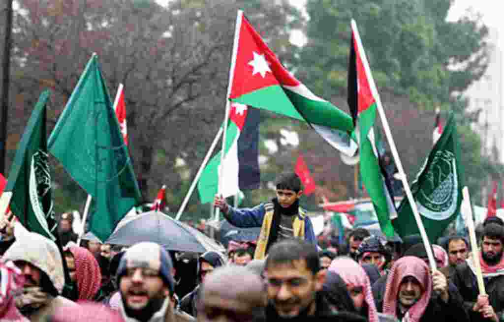 A Jordanian boy holds a national flag during a protest against Jordan's new Prime Minister Marouf Al Bakhit and in support of the Egyptian people in Amman, Jordan, February 4, 2011