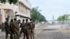 FILE - Benin soldiers stand outside a polling station during the Benin Presidential election in Cotonou on April 11, 2021. Six soldiers were killed in a militant attack Feb. 15, 2025.