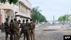 FILE - Benin soldiers stand outside a polling station during the Benin Presidential election in Cotonou on April 11, 2021. Six soldiers were killed in a militant attack Feb. 15, 2025.