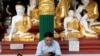 A man wears a face mask as he uses his phone at Shwedagon Pagoda in Yangon, Myanmar January 31, 2020. REUTERS/Ann Wang