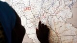 FILE - Evalina, a South Sudanese teenage victim of sexual abuse, points on a map to Unity state in South Sudan, indicating the location where she used to live, March 9, 2015. She said she escaped to Khartoum after being imprisoned by gunmen.