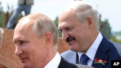 Archivo - El presidente ruso, Vladimir Putin, (izquierda) y el presidente bieloruso, Alexander Lukashenko, saludan a veteranos de la II Guerra Mundial durante una ceremonia en Rzhev, 200 km al oeste de Moscú, Rusia, el 30 de junio de 2020.