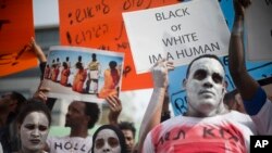 African migrants hold signs during a protest in front of the Rwandan embassy in Herzeliya, Wednesday, Feb. 7, 2018. On April 2, Israel announced a deal to resettle African migrants in Israel and the West, but backtracked on it hours later. (AP Photo/Ariel Schalit)