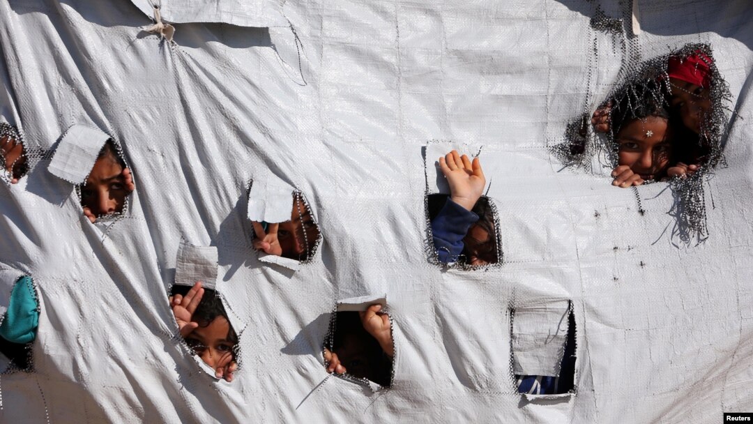 Children look through holes in a tent at al-Hol displacement camp in Hasaka governorate, Syria April 2, 2019. Picture taken April 2, 2019. REUTERS/Ali Hashisho