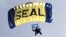 A U.S. Navy SEAL, who is a member of the Navy parachute team 'Leap Frogs', takes part in a demonstration of combat skills at the National Navy UDT-SEAL Museum in Fort Pierce, Florida November 11, 2011. 