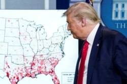 President Donald Trump walks past a U.S. map of reported coronavirus cases as he departs following a coronavirus disease (COVID-19) news briefing at the White House in Washington, July 23, 2020.