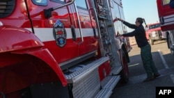 Firefighters get ready to head back to the fire line at the first responders base camp set up at Zuma Beach, on Jan. 13, 2025, in Malibu, California.