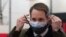 Congressman Jim Himes adjusts his two masks during a tour of a vaccination clinic, Feb. 10, 2021, at a high school in Bridgeport, Conn.
