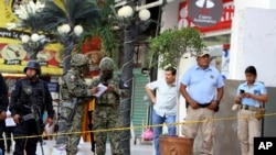 Soldiers from the National Guard, State Police officers of Guerrero and Municipal Police officers of Acapulco guard an area where gunmen killed and wounded multiple people inside a bar in Acapulco, Mexico, July 21, 2019. 