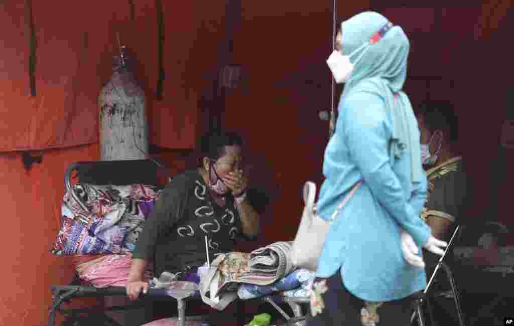 A woman sits inside an emergency tent accommodating a surge of COVID-19 patients at a hospital in Bekasi, West Java, Indonesia.